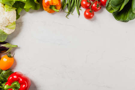 Stone background with a border of fresh vegetables.  Top view.の写真素材