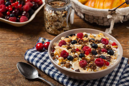 Breakfast, muesli with milk and fresh fruit. Front view.
