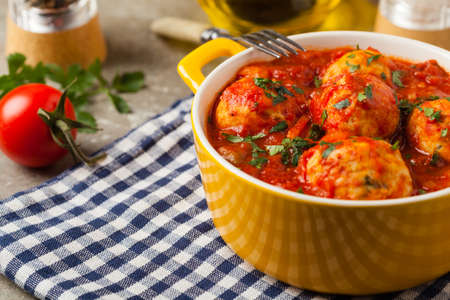Chicken meatballs with tomato sauce. Served with rice. Front view. Stone background.の写真素材