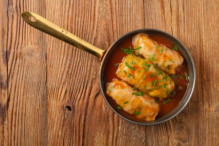 Traditional stuffed cabbage with minced meat and rice, served in a tomato sauce. Top view. Flat lay.