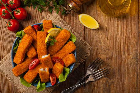 Fish sticks with salad in blue bowl. Top view.の写真素材