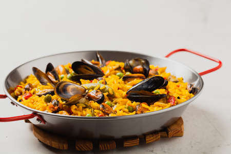 Traditional paella with mussels. Front view. Stone white background.の写真素材