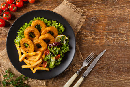 Roasted squid rings with fries. Top viewの写真素材