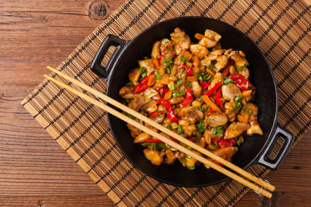 Chicken kung pao. Fried chicken pieces with peanuts and peppers. Top view. Flat lay.の写真素材