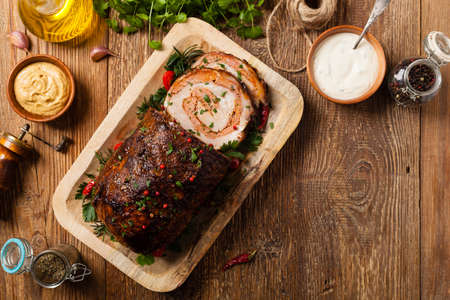 Roasted whole, stuffed with minced pork neck. Top view. Natural wooden background.の写真素材