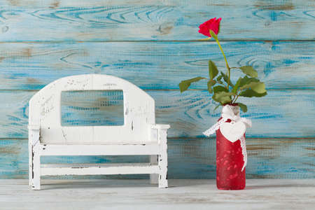 Valentine's Day. Rose in a vase on blue wooden background.の写真素材