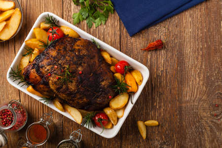 Roasted whole shoulder, with potatoes, peppers and tomatoes. Marinated in white wine.Top view....