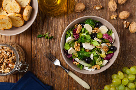 Italian spring salad with goat cheese, grapes and walnuts. Served with croutons. Top view.の写真素材