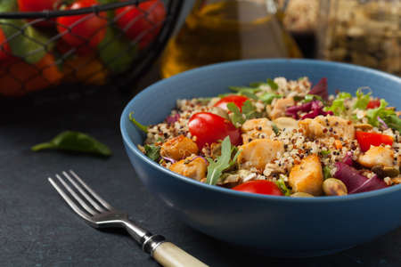 Salad with quinoa, avocado and chicken. Front view. Served in a blue bowl.の写真素材