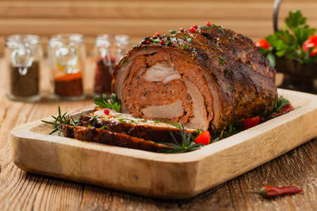 Roasted whole, stuffed with minced pork neck. Front view. Natural wooden background.の写真素材