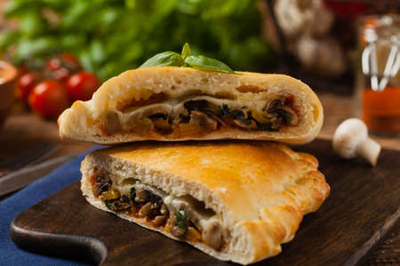 Italian calzone with mushrooms and ham. Front view.の写真素材