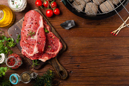 Raw beef steak, ready for grilling. Grill accessories. Concept. Copy space for text. Top view.の写真素材