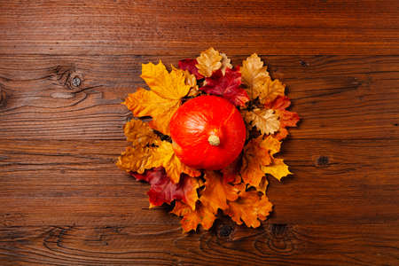 Wooden background. Arranged autumn leaves and pumpkins. Top view.の写真素材