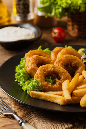 Roasted squid rings with fries. Front viewの写真素材