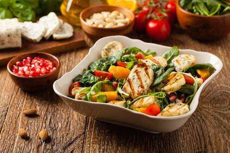 Traditional Greek salad with grilled Halloumi cheese with basil. Front view.の写真素材