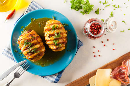 Baked potatoes in Swedish. Hasselback. Stuffed with cheese and bacon. Top view. の写真素材