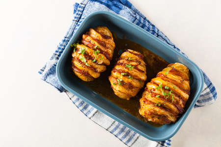 Baked potatoes in Swedish. Hasselback. Stuffed with cheese and bacon. Top view. の写真素材