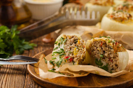 Onion baked with cheese stuffed with minced meat. Front view.  Served in parchment.の写真素材