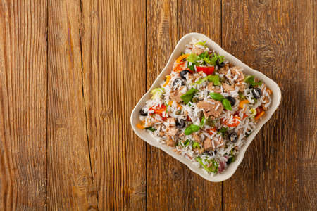 Italian tuna salad with rice, olives and capers. Top view. Natural wooden background.の写真素材