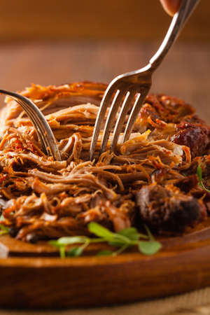 Pulled pork on a wooden board.