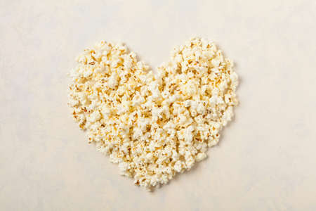Heart background made of chips, prays and/or popcorn. Top view.の写真素材