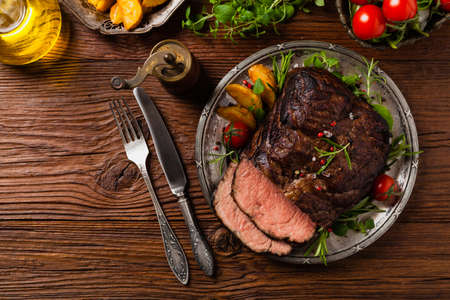 Roasted brisket. Rustic style, natural wooden background. Dark style. Top view. Flat lay.の写真素材