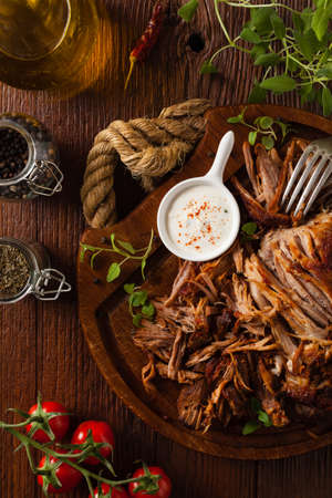 Pulled pork on a wooden board. Top view.