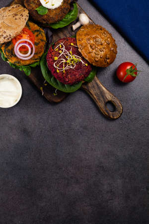 Vege burgers with carrots, beetroots and mushrooms. Top view. Black background.の写真素材