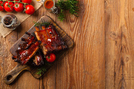 Roasted pork ribs in a bbq sauce. Served on a wooden board. Top view.の写真素材