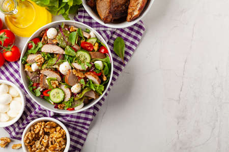 Salad with pork tenderloin, fresh cucumber and mozzarella. Top view.の写真素材