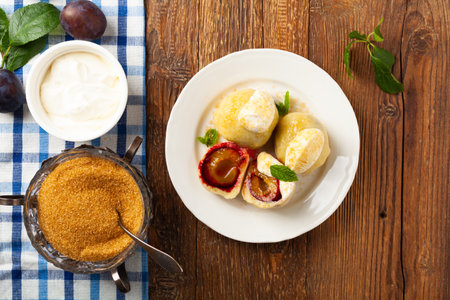 Dumplings with plums, topped with plum sauce or served with cream and sugar. Top view.の写真素材
