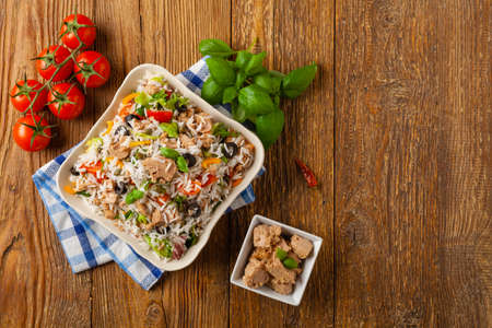 Italian tuna salad with rice, olives and capers. Top view. Natural wooden background.の写真素材