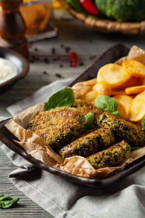 Vegetarian spinach and broccoli meatballs, served with yogurt dip and toasted potatoes. Front view.の写真素材