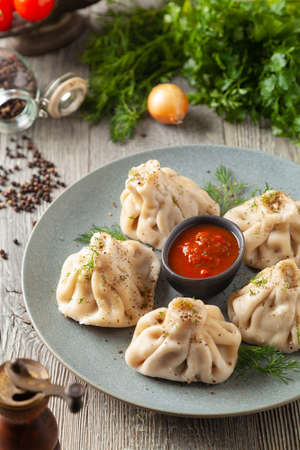 Traditional Georgian dumplings with meat. Khinkali. Served on a plate with traditional Georgian bread. Wooden background.の写真素材