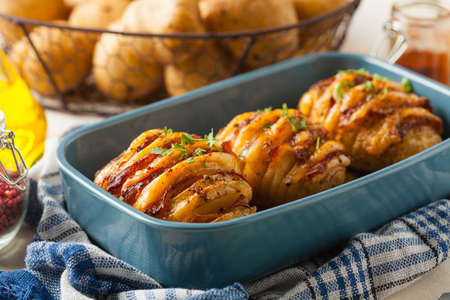 Baked potatoes in Swedish. Hasselback. Stuffed with cheese and bacon. Top view.の写真素材