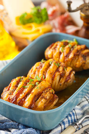 Baked potatoes in Swedish. Hasselback. Stuffed with cheese and bacon. Top view.の写真素材