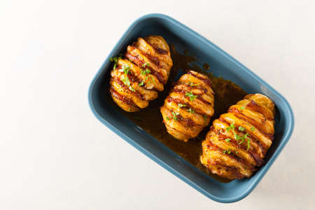 Baked potatoes in Swedish. Hasselback. Stuffed with cheese and bacon. Top view.の写真素材