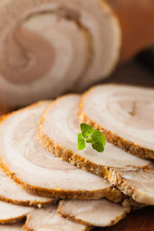 Whole bacon roulade. Served in sliced meat with white sauce. Front view.の写真素材