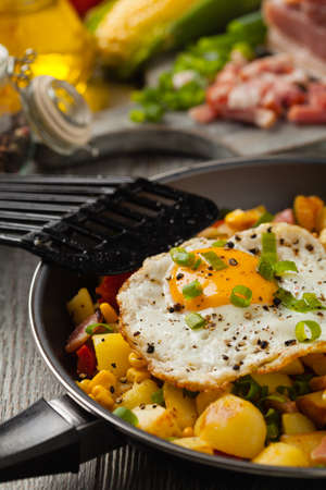 Traditional American hash with fried eggs. Front view.の写真素材