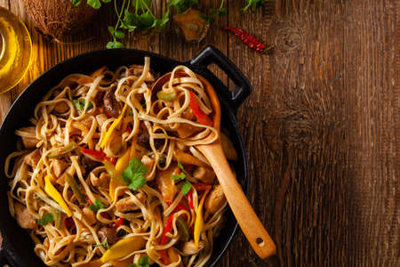 Fried chicken with mango and coconut milk with noodles. Prepared in a wok. Top view.の写真素材