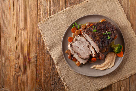 Whole roasted pork neck, stewed in wine with vegetables. Served with applesauce. Traditional Swiss dish.の写真素材