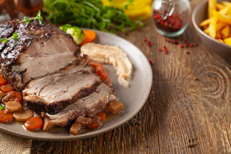Whole roasted pork neck, stewed in wine with vegetables. Served with applesauce. Traditional Swiss dish.の写真素材