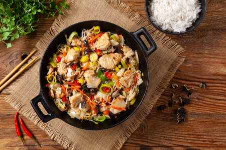 Chinese style cod, prepared in a wok. Natural wooden background.の写真素材