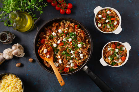 Traditional Greek cuisine. Lamb stew with feta cheese and vegetables. Dark background.の写真素材