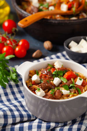 Traditional Greek cuisine. Lamb stew with feta cheese and vegetables. Dark background.の写真素材