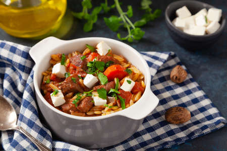 Traditional Greek cuisine. Lamb stew with feta cheese and vegetables. Dark background.の写真素材