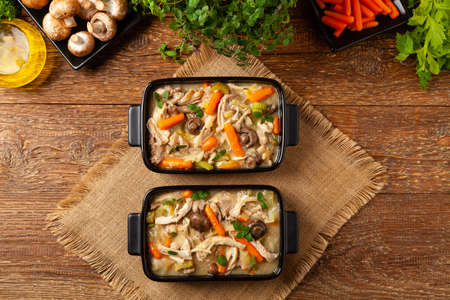 Traditional chicken stew with mushrooms and vegetables. Chicken casserole. Served in black pots.の写真素材