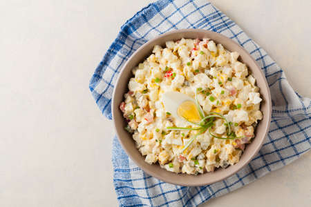 A light egg salad with celery, gherkin, pepper and mayonnaise. Served in a bowl on a light background. Top view.の写真素材
