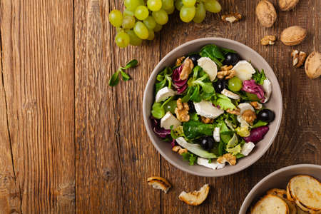 Italian spring salad with goat cheese, grapes and walnuts. Served with croutons. Top view.の写真素材