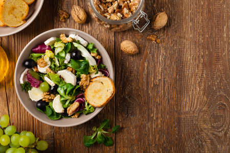 Italian spring salad with goat cheese, grapes and walnuts. Served with croutons. Top view.の写真素材
